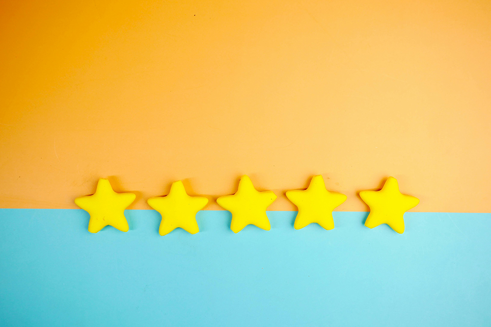 Five yellow stars arranged in a row on a colorful background, symbolizing high ratings and customer reviews.