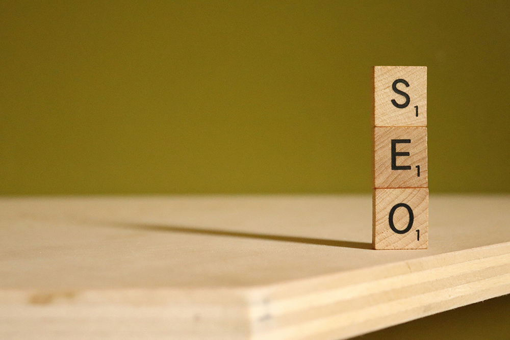 Wooden blocks spelling "SEO" stacked on a wooden surface, representing search engine optimization and digital visibility.