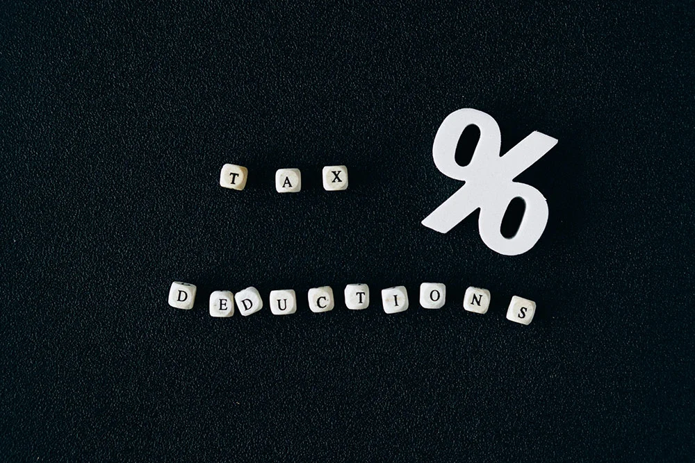 White letter blocks spelling TAX DEDUCTIONS next to a percentage sign
